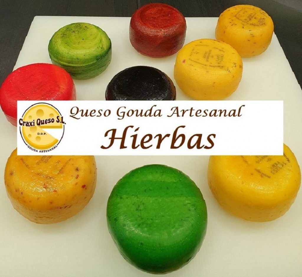 Surtido de quesos aromatizados para una tabla de quesos. Queso Gouda artesanal a partir de leche cruda de vaca con hierbas y especias