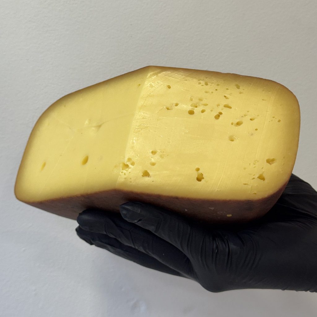 Este queso ahumado de vaca se ahúma con madera de roble en un ahumadero. Gouda ahumado artesanal elaborado con leche cruda de vaca.